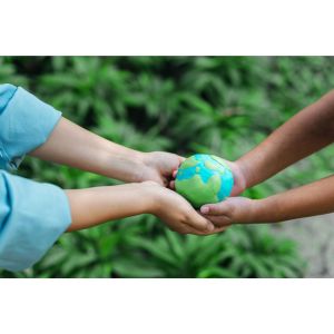 Arms of two people hold a miniature globe