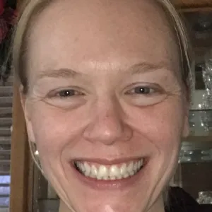 Megan Papadakos, with hair pulled back. Smiling.