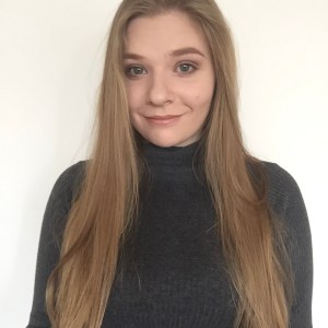 A profile of a woman with long blonde hair, wearing a black shirt