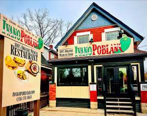 Exterior of IvanoPoblano, a 100% organic Mexican restaurant, with signage featuring a green chili pepper and a charming brick-front building